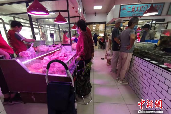 图为北京市西城区一家菜市场，不少人正在买肉。 <a target='_blank' href='http://www.chinanews.com/' >中新网</a>记者 谢艺观 摄