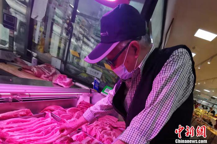 在北京市西城区一家菜市场，一位大爷正在挑肉。 <a target='_blank' href='http://www.chinanews.com/' >中新网</a>记者 谢艺观 摄