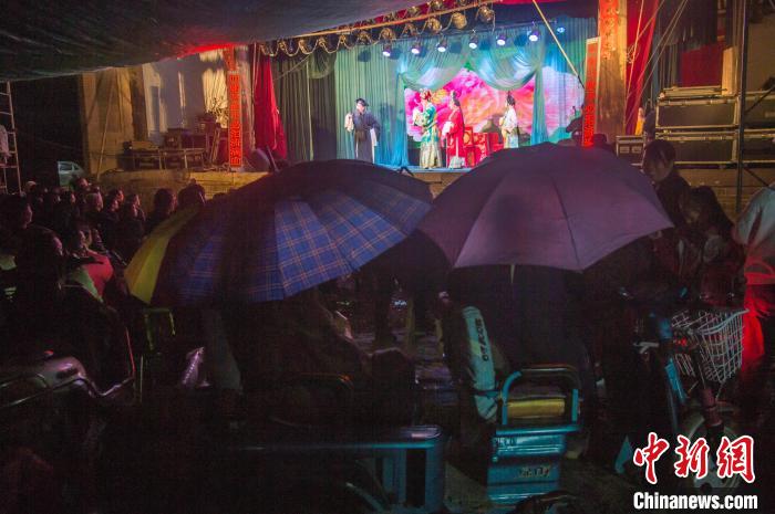 民众在雨中观看蒲剧。 武俊杰 摄